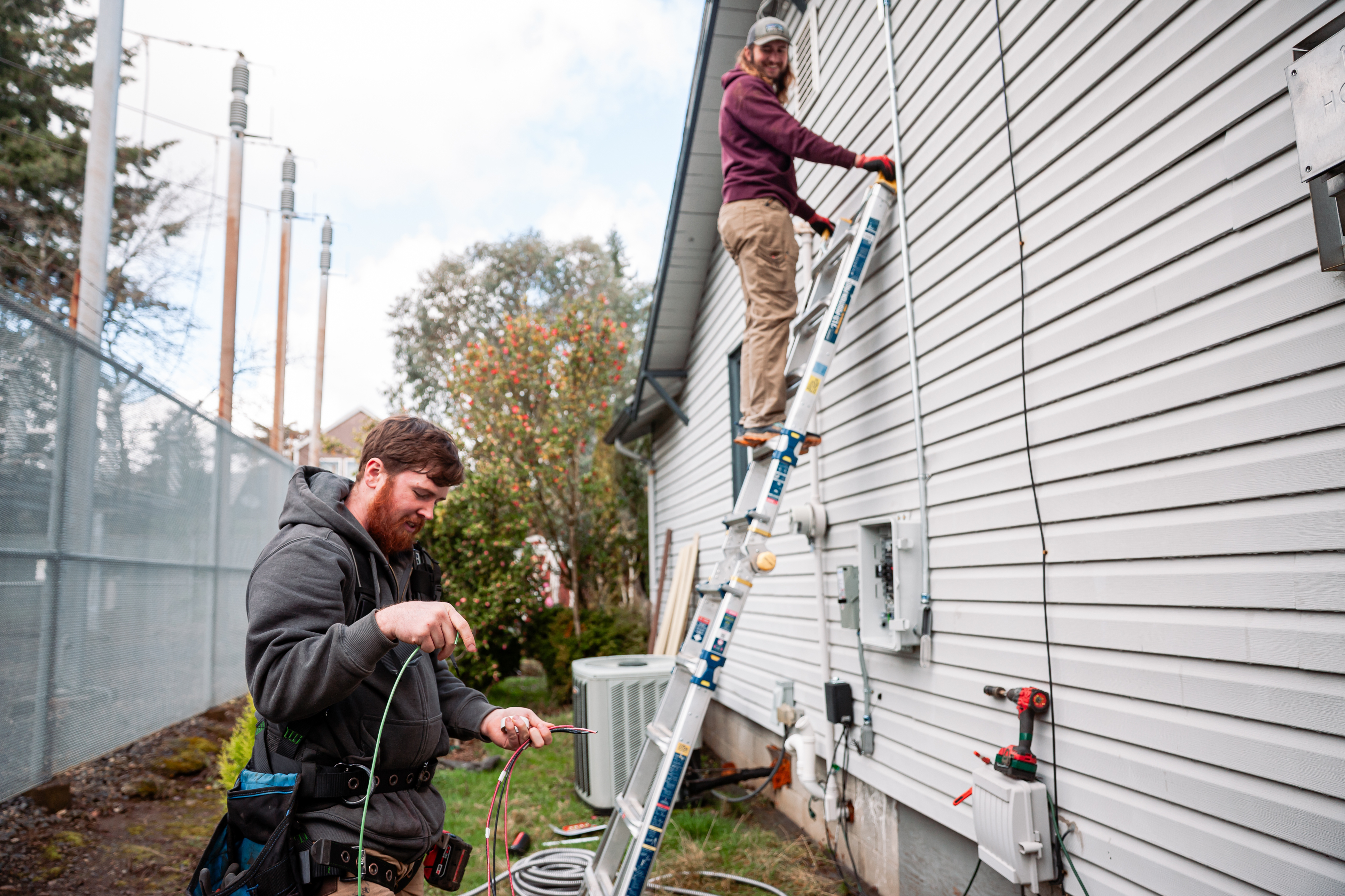A%20professional%20solar%20technician%20installing%20a%20Solar%20Panel%20Electric%20Box%20on%20the%20side%20of%20a%20house A%20professional%20solar%20technician%20installing%20a%20Solar%20Panel%20Electric%20Box%20on%20the%20side%20of%20a%20house